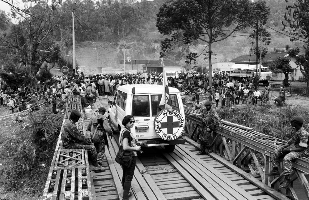 This picture was taken at the end of the Rwandan genocide on 20 August 1994. About 1’500 Rwandan refugees at the time crossed the Ruzizi Bridge to get to Zaire, where they invaded the city of Bukavu. Here the Rwanda-Zaire border is temporarily closed. As revealed in the picture, frontline negotiations happen in tense and insecure environments, the results of which are often life-saving operations for the population concerned