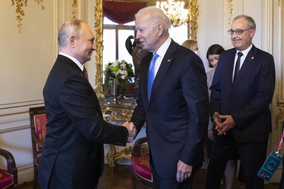 Le président russe Vladimir Poutine, à gauche, serre la main du président américain Joe Biden à côté du président de la Confédération suisse Guy Parmelin, à l'arrière, lors du sommet États-Unis - Russie le 16 juin 2021